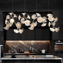 Floral branch chandelier illuminating a marble kitchen island