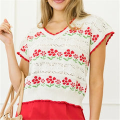 A woman modeling a floral knit sweater pullover vest.