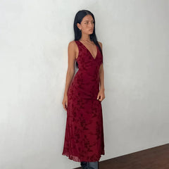 A woman wearing a floral print long dress with a V-neckline.