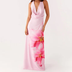 A woman wearing a floral print halterneck maxi dress.