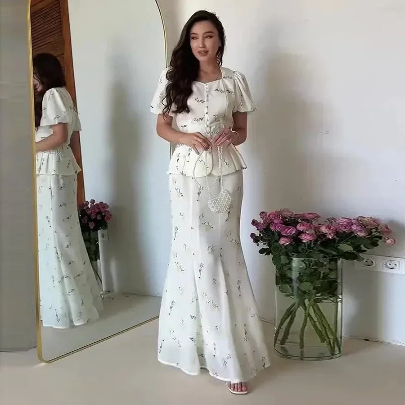 A woman wearing a two-piece floral printed shirt and skirt set.