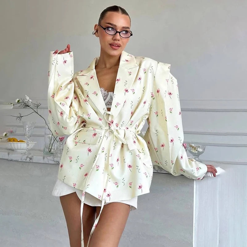 Floral waist-tie blazer worn by woman indoors in relaxed pose