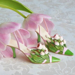 Flower decor women’s party stilettos in green and pink for spring fashion on a light background