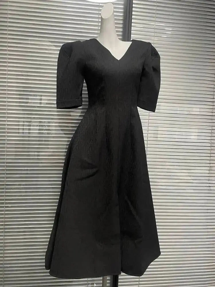 Three-quarter angle of the dress capturing the drape and volume through the skirt, styled simply for a formal, modern look.