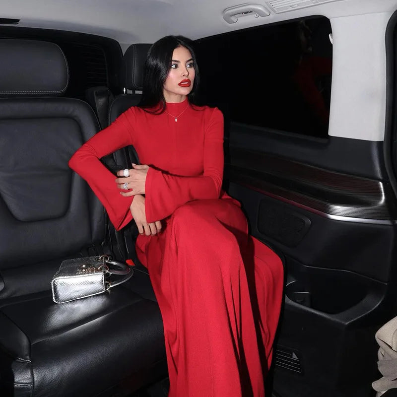 Woman in a formal A-line flare sleeve evening dress shown for upscale occasions sitting in the back of a black limousine.