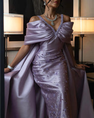 An exquisite formal party dress with a sweeping train and a unique cape overskirt.
