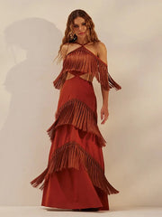 Woman wearing a fringe halter, hollow out bandage dress styled for festive parties against a plain background