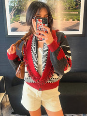 Model wearing a patterned shawl-collar cardigan with fringe trim, styled as an easy layered look.
