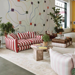 “Artistic living space styled with striped couch and floral ottoman”