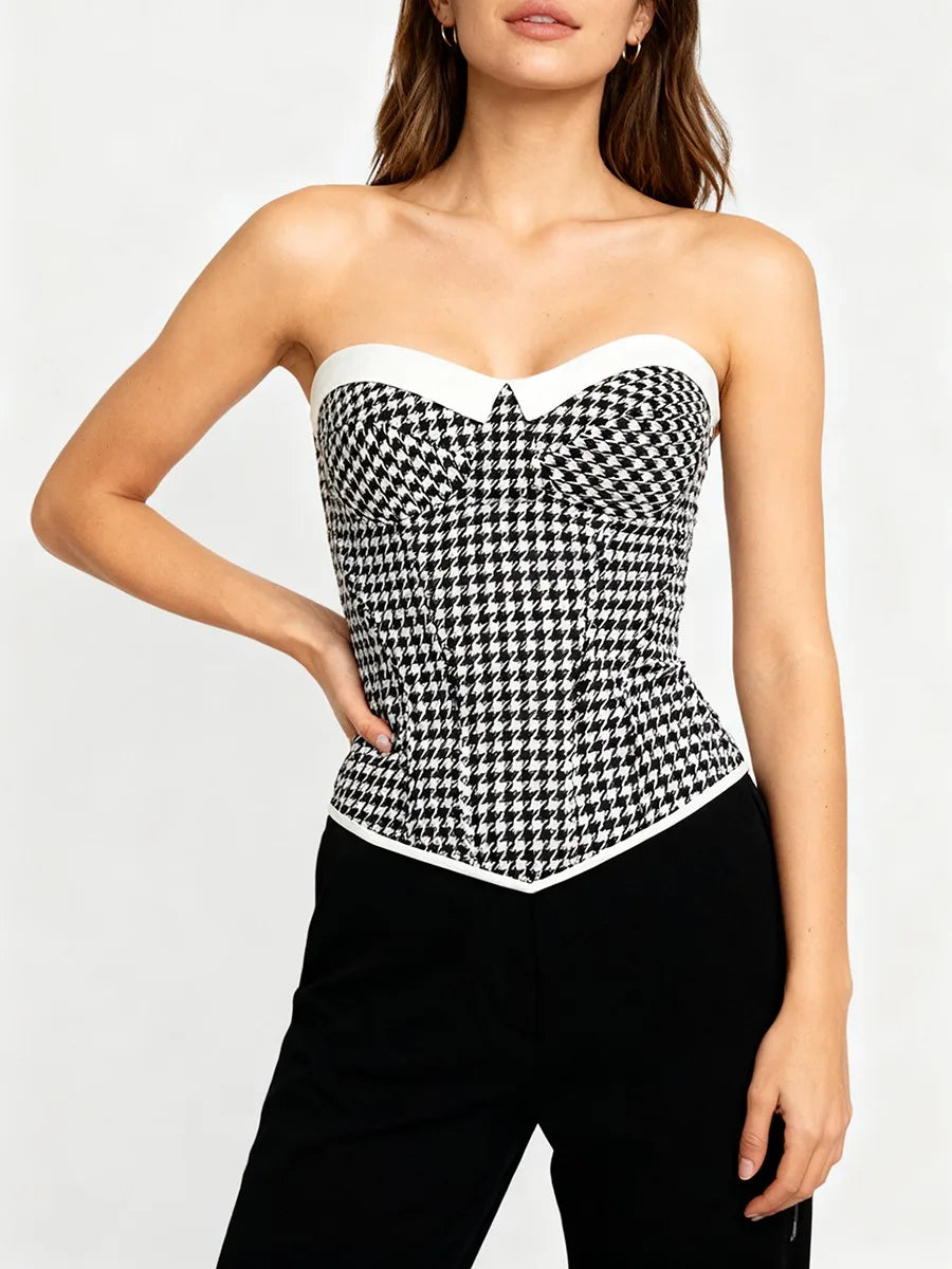 Woman wearing a gingham strapless corset top styled with black trousers, showcasing a tailored cropped silhouette in bright summer lighting.