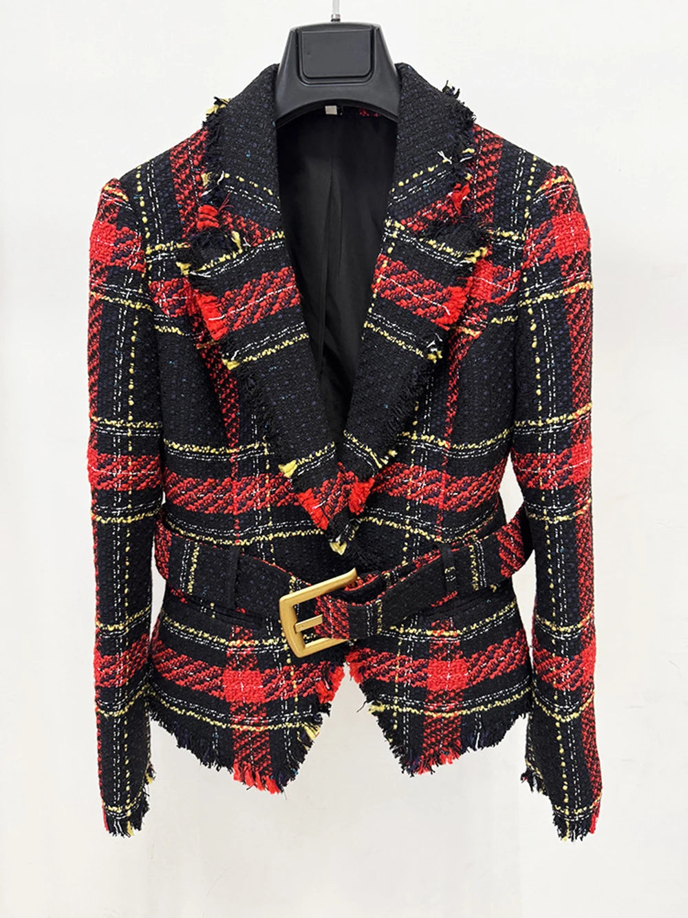 Front close view highlighting the notched lapel, deep V opening, and textured tweed weave with bold plaid lines and a waist-cinching belt