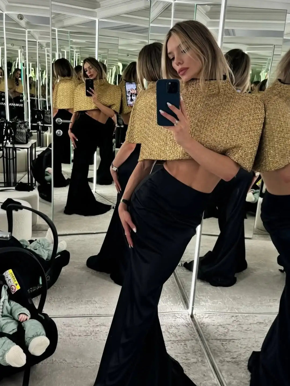Indoor styling shot showing a gold sparkle cape top paired with a high-waisted skirt for a sleek party dinner outfit.