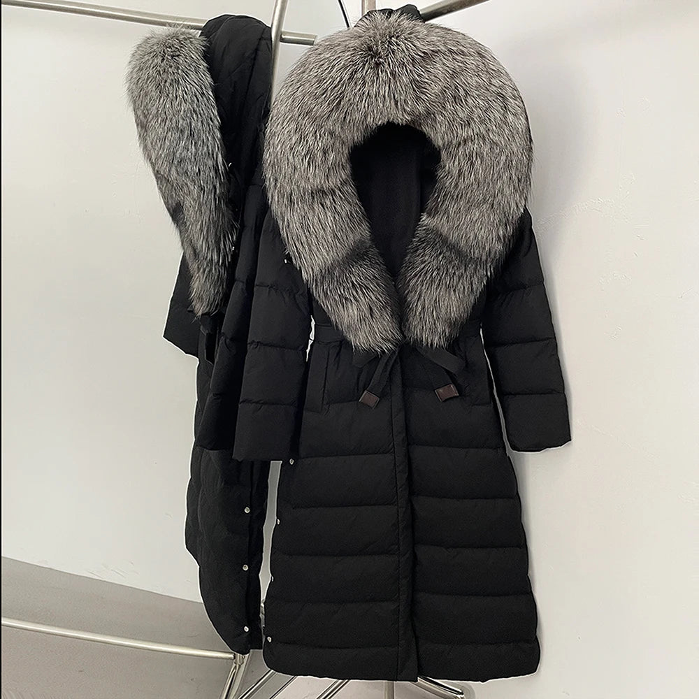 Close view of the dramatic fur-trim hood framing the neckline, showing dense texture contrast against the smooth black shell.