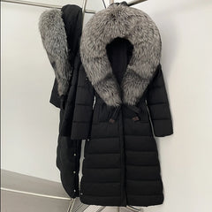 Close view of the dramatic fur-trim hood framing the neckline, showing dense texture contrast against the smooth black shell.