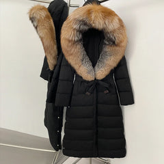 Long black puffer coat on a hanger with oversized warm-toned fur-trim hood, belted waist, and sleek quilted panels.
