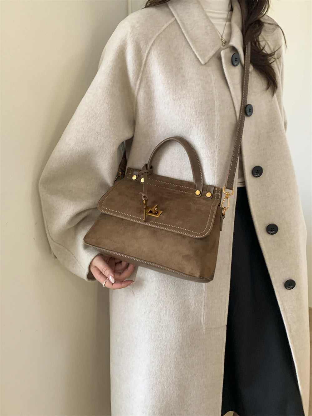 Brown faux suede crossbody handbag with top handle and polished hardware