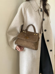 Brown faux suede crossbody handbag with top handle and polished hardware