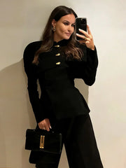 Woman wearing a black tailored blazer coat with metallic buttons