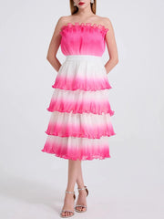 A woman modeling a gradient tiered ruffle dress with a square neckline and spaghetti straps.