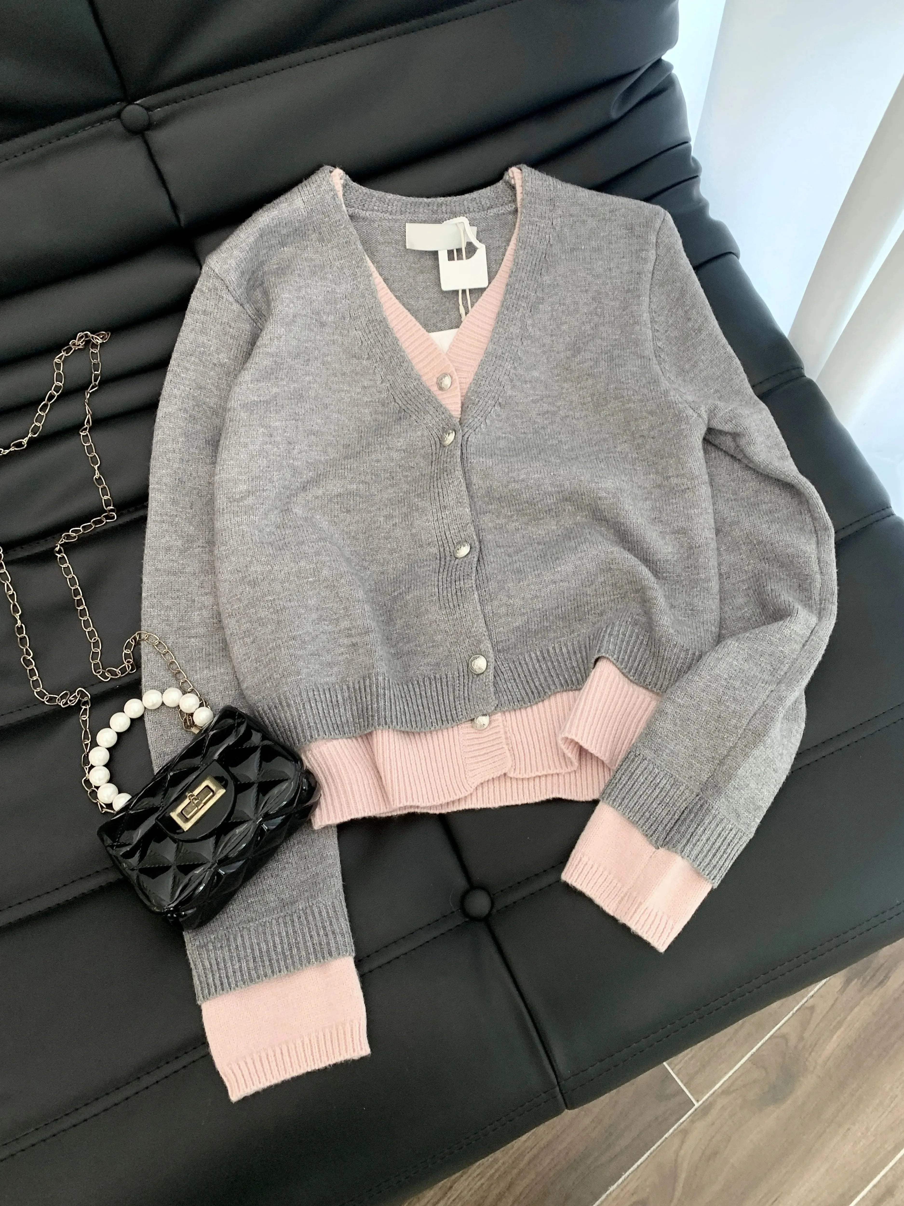 Gray cardigan with pink trim folded on chair for junior autumn