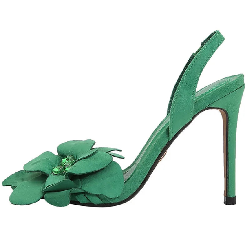 Green crystal flower high heel sandals styled for a formal party outfit. Green high-heeled shoe with floral design on a white background