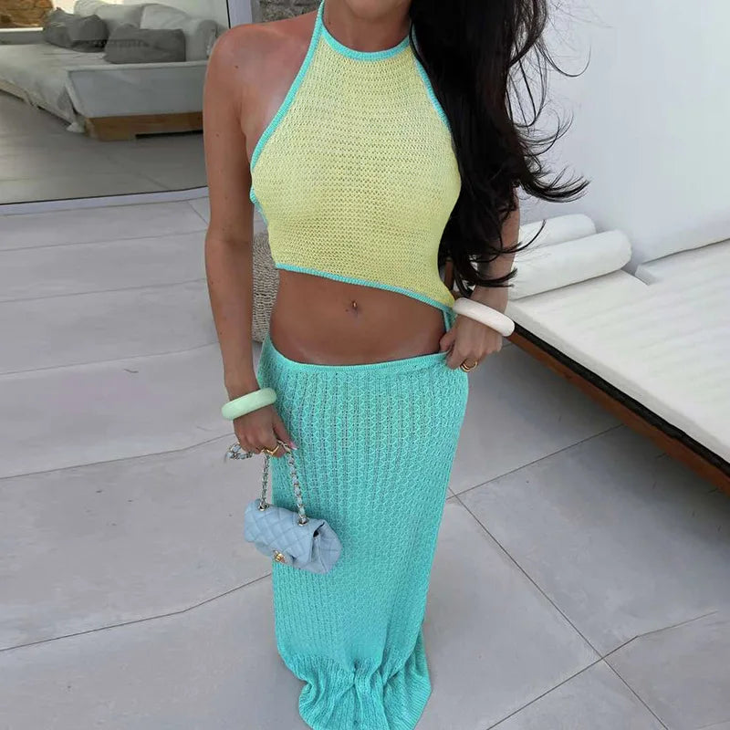 Woman wearing a  green knit halter crop and maxi skirt beach set styled for vacation in an indoor setting