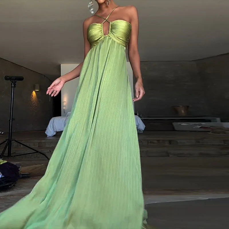 Green pleated satin maxi dress styled for elegant vacation evenings