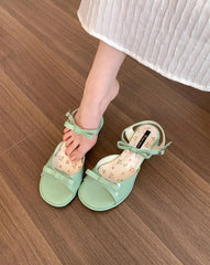 Close-up of green PU sandals with butterfly knot strap