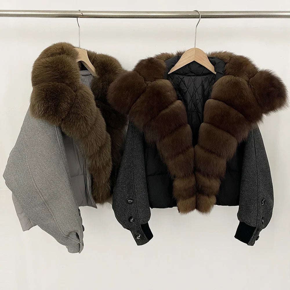 Two grey jackets layered on a rack, highlighting the relaxed shape, cropped hemline, and structured padded panels under soft studio light.