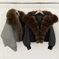 Two grey jackets layered on a rack, highlighting the relaxed shape, cropped hemline, and structured padded panels under soft studio light.