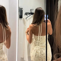 back view showing lace up open back on ivory halter dress