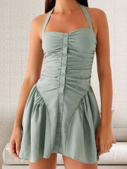 A woman modeling a black halter neck ruched mini dress with a corset waist.