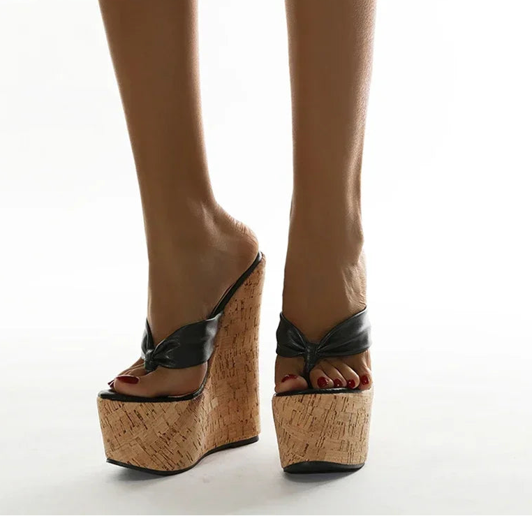 A side view of the slippers showing the wedge heel and platform.