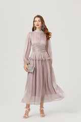 Model wearing a light silver chiffon midi dress with a high neckline and long lantern sleeves, holding the skirt to show movement.