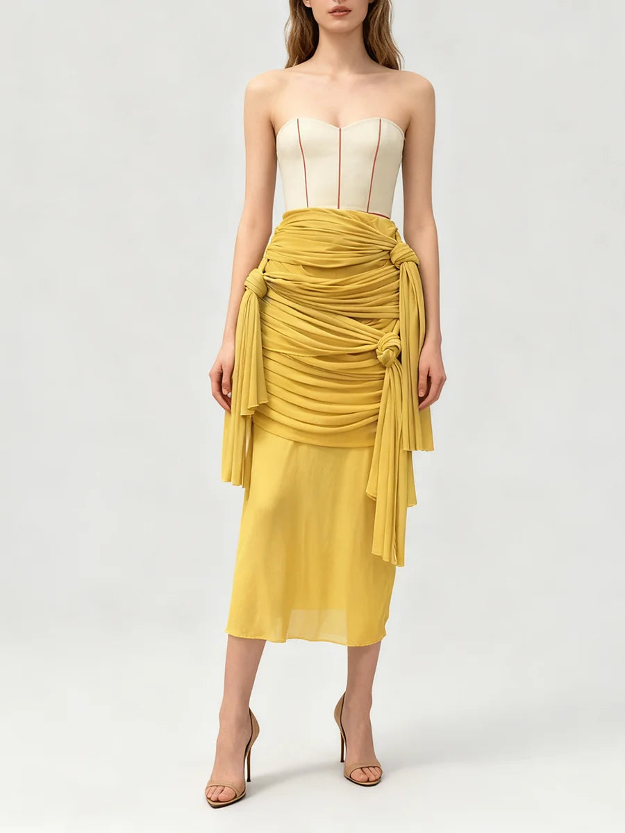 Front view of a yellow sculptural midi skirt with layered folds.