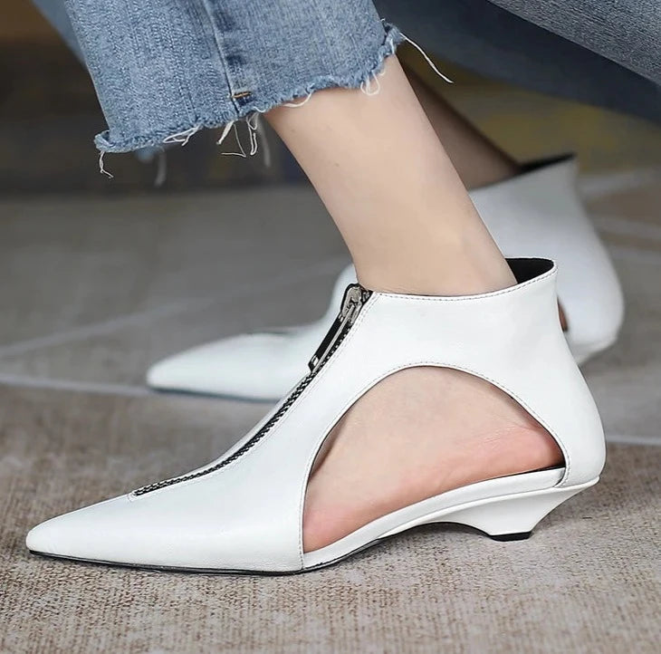 Close-up of hollow cutout low heel white leather ankle shoes