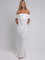 Woman wearing a white lace off-shoulder gown against a gray background
