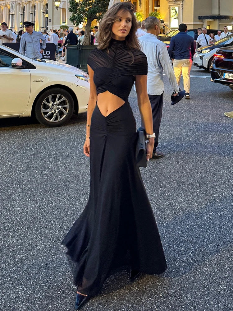 A woman modeling a hollow-out ruched mini dress for a night out.