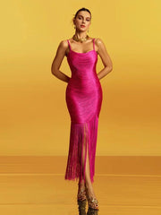 Bright pink spaghetti-strap midi dress on a yellow studio backdrop, showing a square neckline and sleek sheath fit through the body.