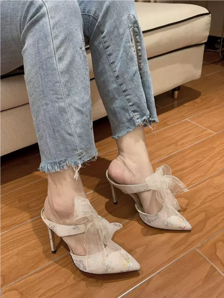 Ivory pointed toe event slip-ons with elegant embroidery and stiletto heel