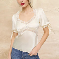 Close-up of the ivory top’s lace trim and satin texture, showing delicate edging and subtle shine under soft light.