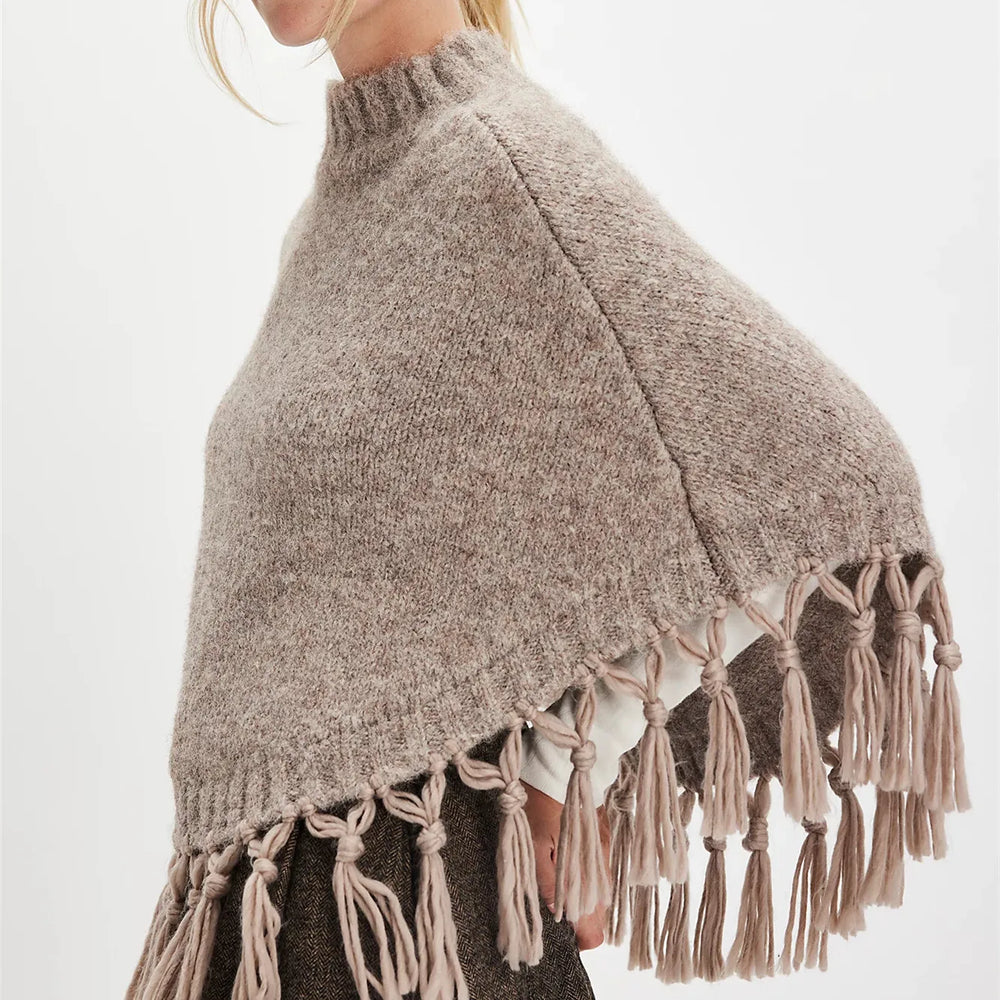 Close view of the tassel hem detailing, highlighting movement and the soft knit finish.