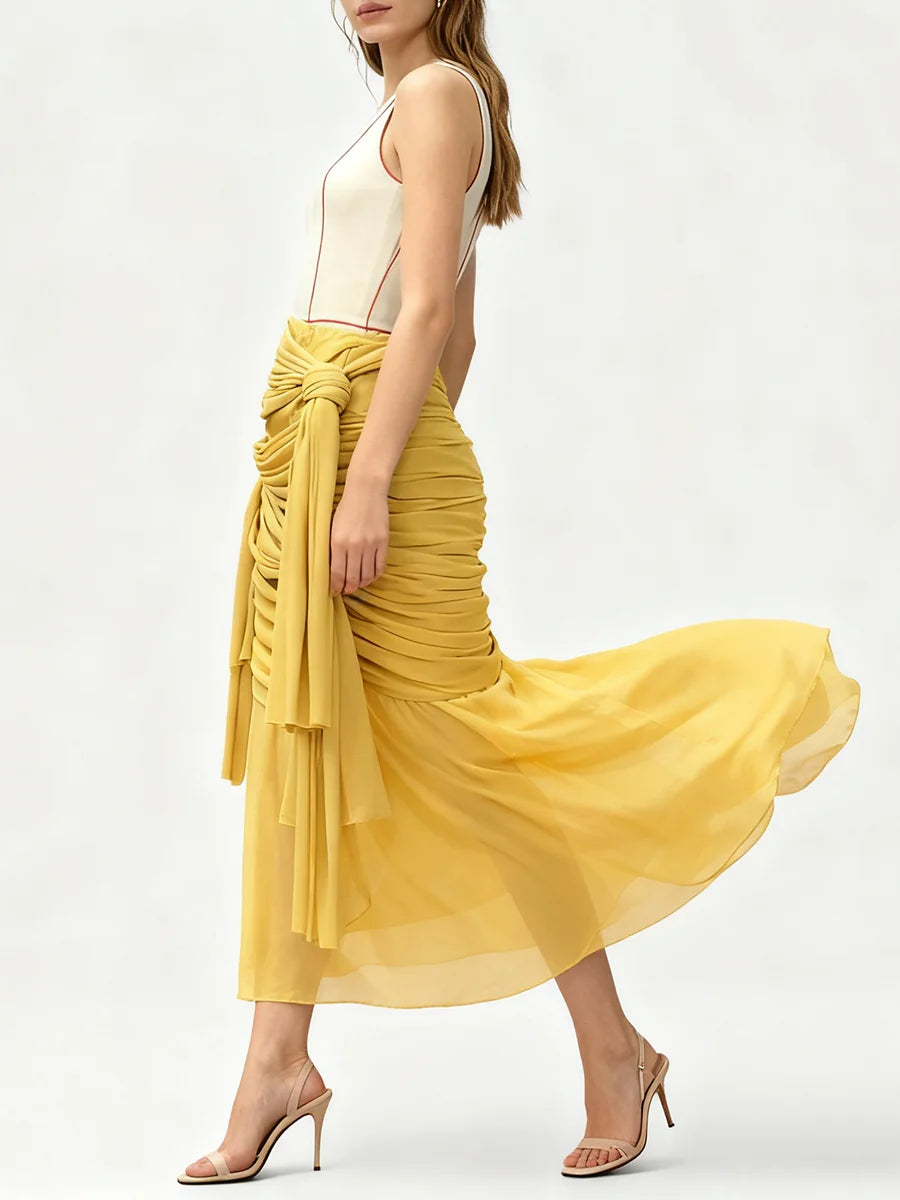 Side profile of a yellow midi skirt with cascading drapes.