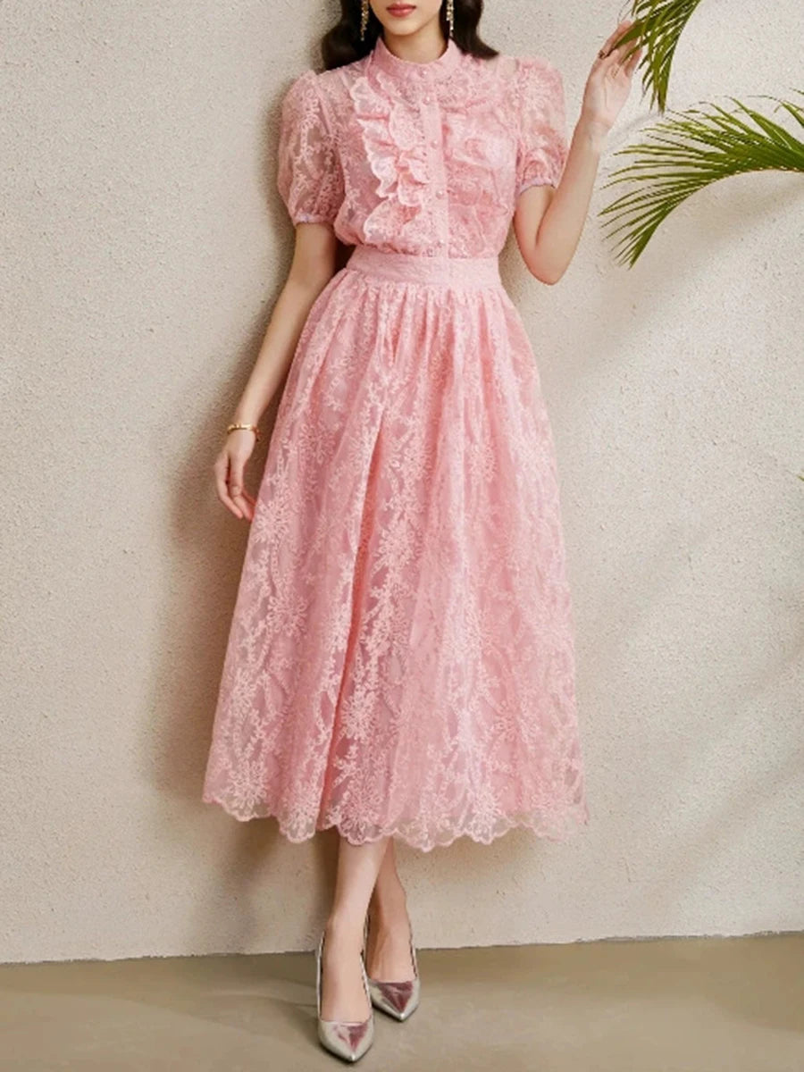A woman modeling a lace midi dress with ruffles and a round neckline.