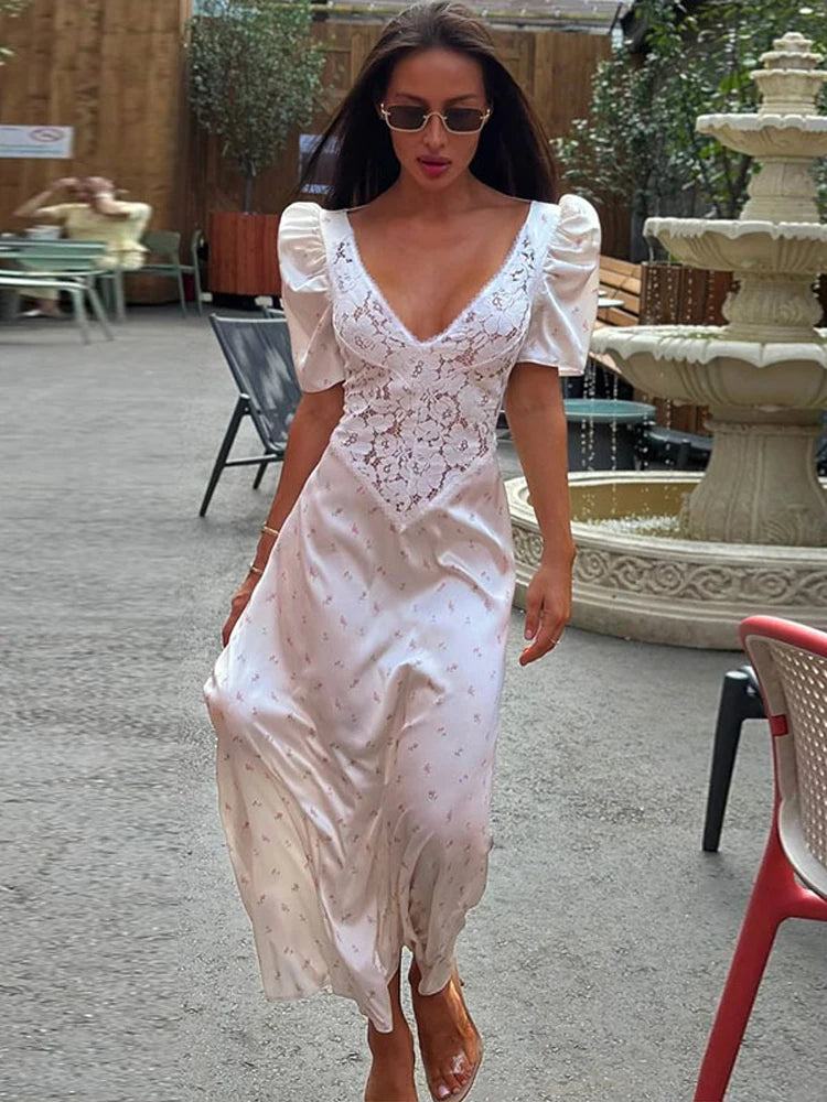 A woman wearing an elegant lace stitching V-neck dress with short puff sleeves.