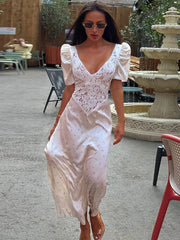A woman wearing an elegant lace stitching V-neck dress with short puff sleeves.