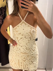 close view of lace pattern and halter neckline on ivory mini dress
