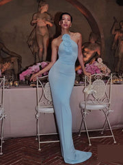 Lace-up sheath long dress for elegant club nights and formal events.  Woman in a light blue dress sis tanding in an elegant indoor setting with statues and floral arrangements.