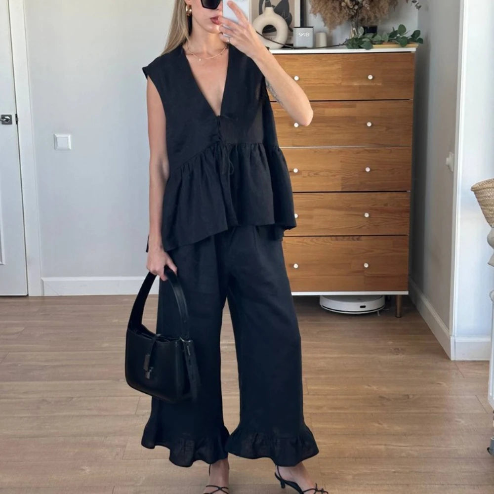 Lace up black sleeveless top paired with wide leg pleated pants