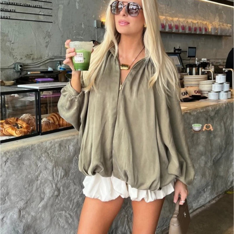 Close view of draped fabric and lantern sleeve shape on a zip jacket